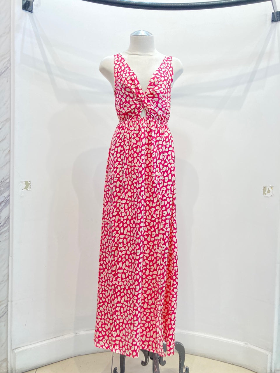 A stylish sleeveless maxi dress featuring a twist-front design and vibrant abstract print, perfect for summer occasions.