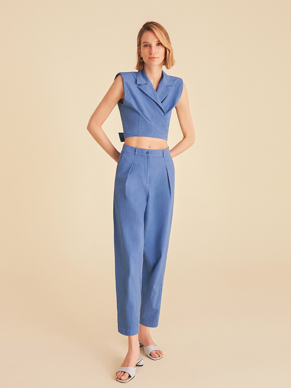 A pair of high-waisted slouchy pants with darts, featuring side pockets and a vibrant color palette of blue and pink, perfect for casual wear.
