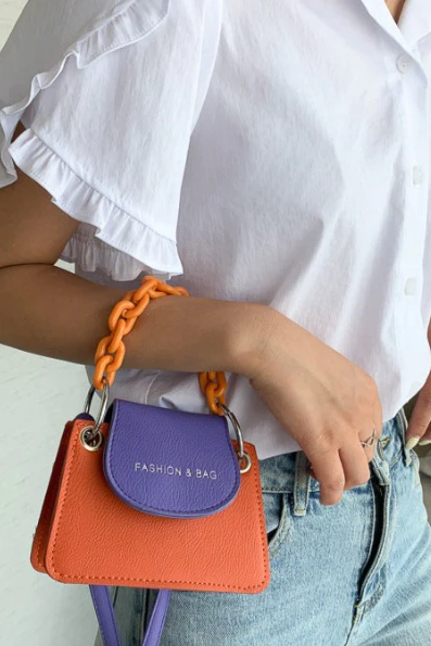 Small bag ART2279 in orange-violet with decorative chain, made of high-quality faux leather.