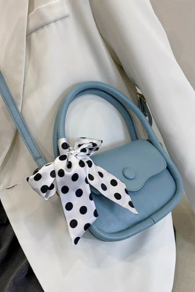 Elegant small blue bag with decorative bow, made of high-quality faux leather, featuring a snap button closure.