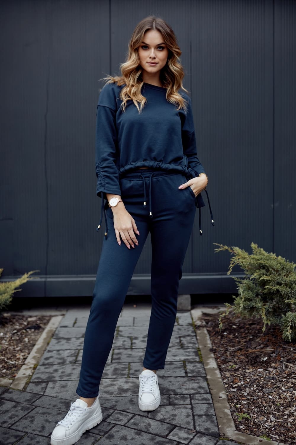Navy blue women's tracksuit featuring an asymmetric sweatshirt and tapered pants, showcasing a stylish and comfortable design.