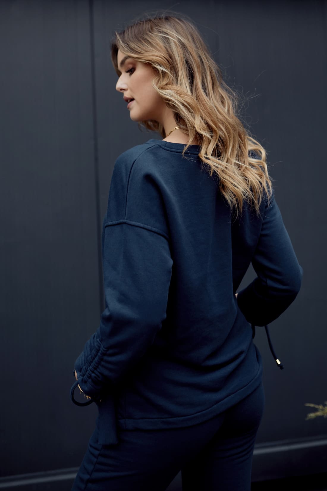 Navy blue women's tracksuit featuring an asymmetric sweatshirt and tapered pants, showcasing a stylish and comfortable design.