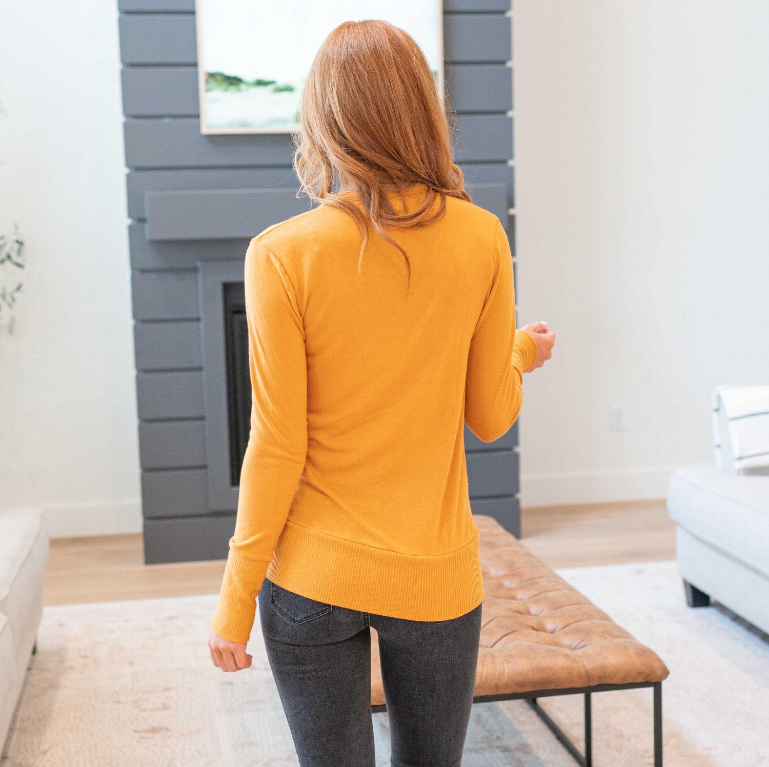 A stylish Snap Button Sweater Cardigan with ribbed texture, featuring button detailing and side pockets, available in various colors.