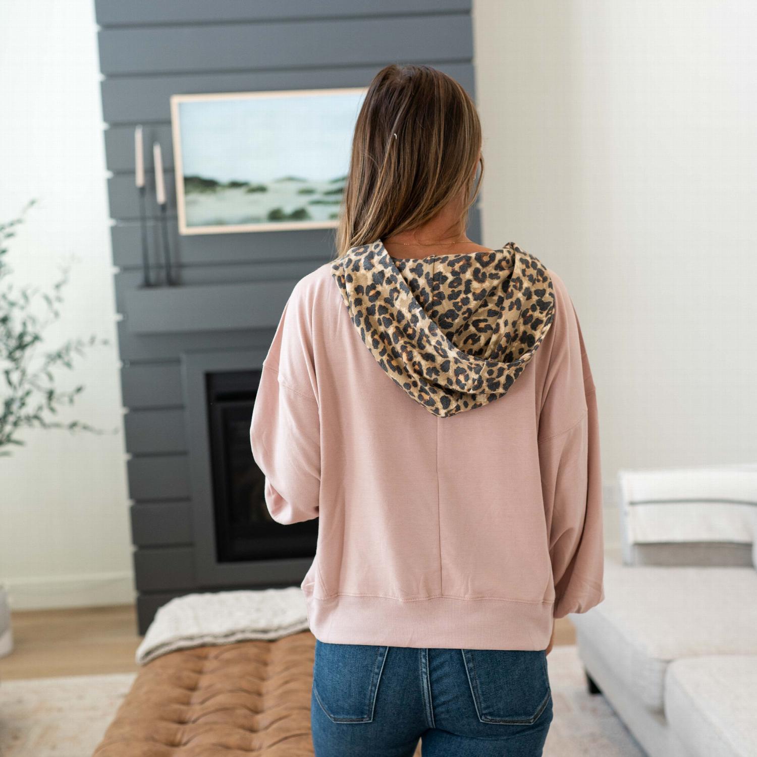 Soft French Terry Reverse Leopard Hoodie featuring a bold leopard print design with a hood and kangaroo pocket.