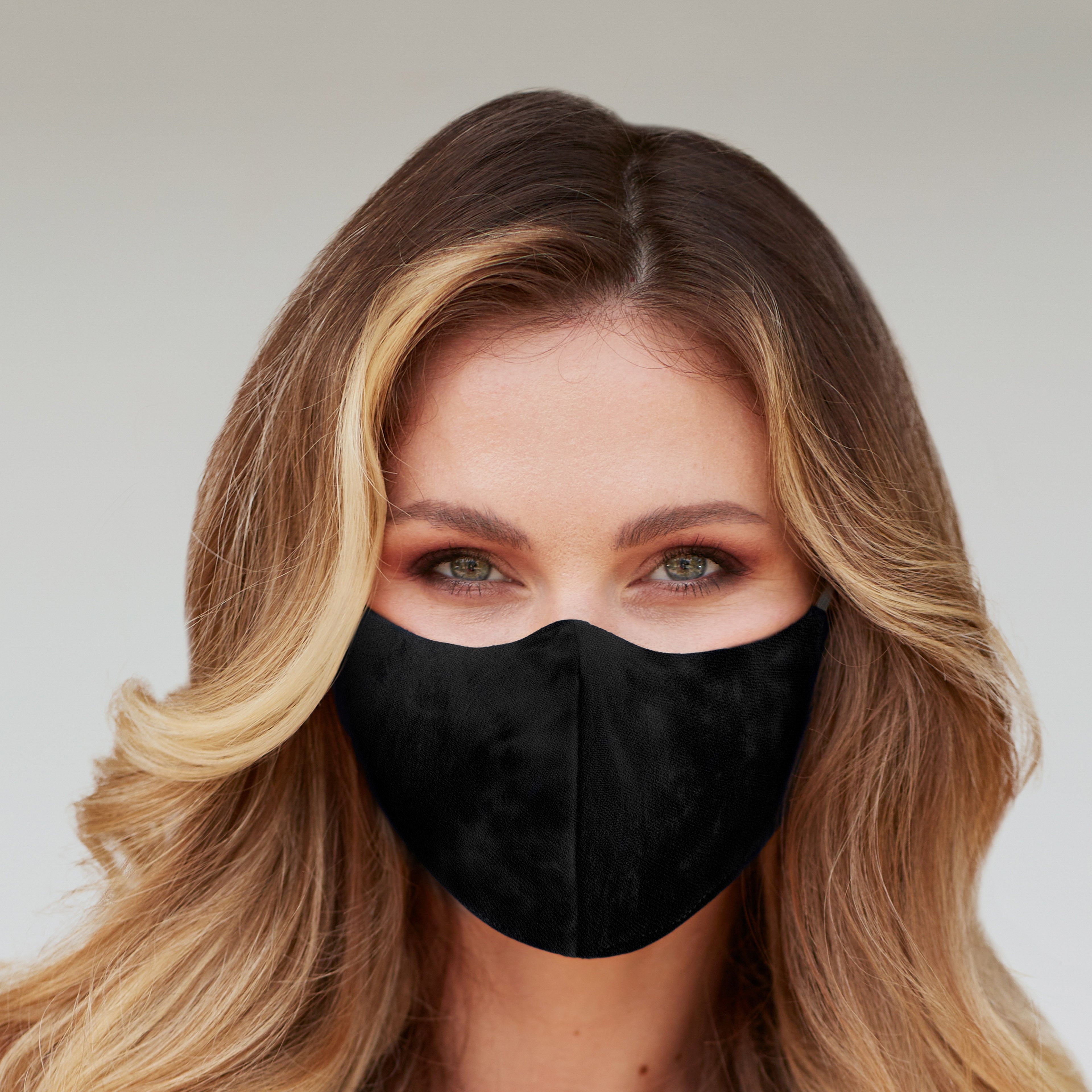 Solid black face mask displayed on a neutral background, showcasing its sleek design and adjustable ear loops.