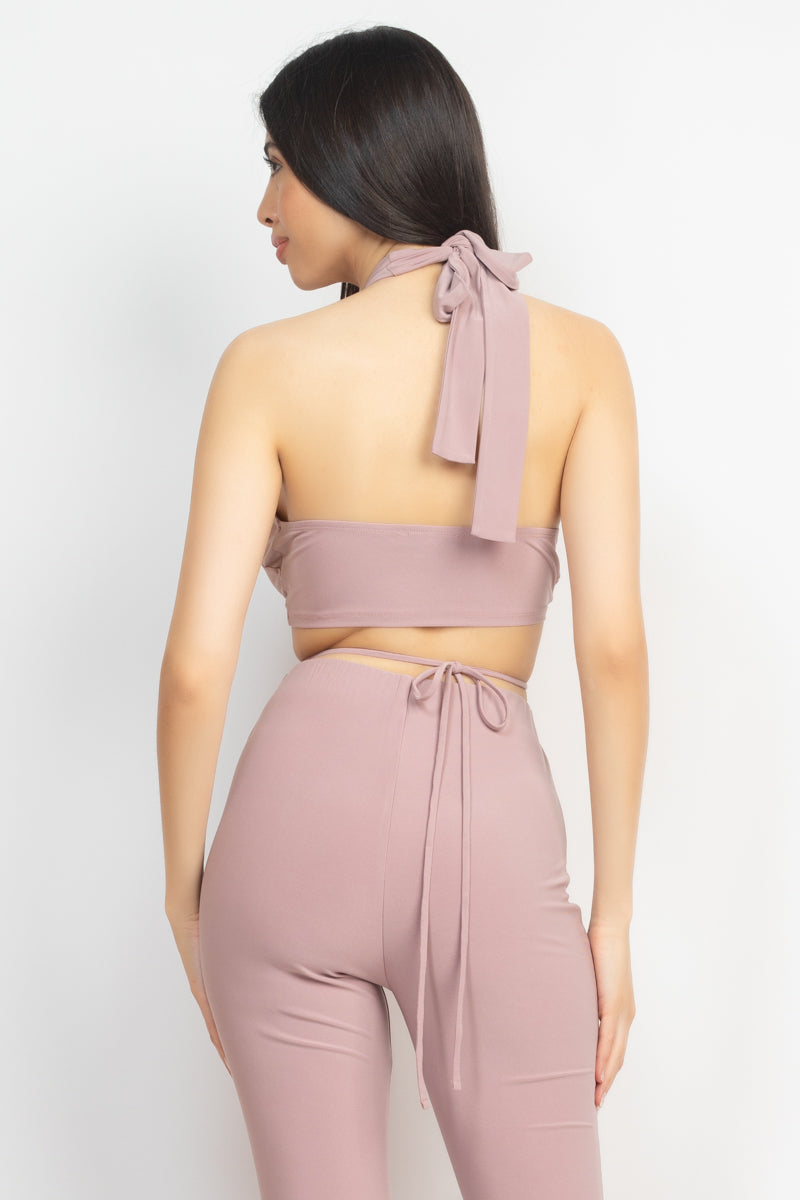 A stylish solid halter top with a drawstring waist and open back, paired with high-rise elastic leggings featuring a bell bottom design.