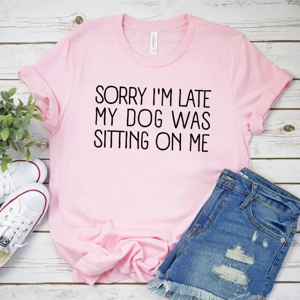 A comfortable unisex T-shirt featuring the phrase 'Sorry I'm Late My Dog Was Sitting On Me', perfect for dog lovers.