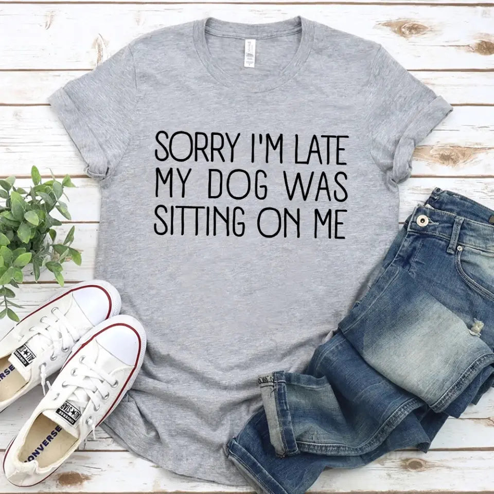 A comfortable unisex T-shirt featuring the phrase 'Sorry I'm Late My Dog Was Sitting On Me', perfect for dog lovers.