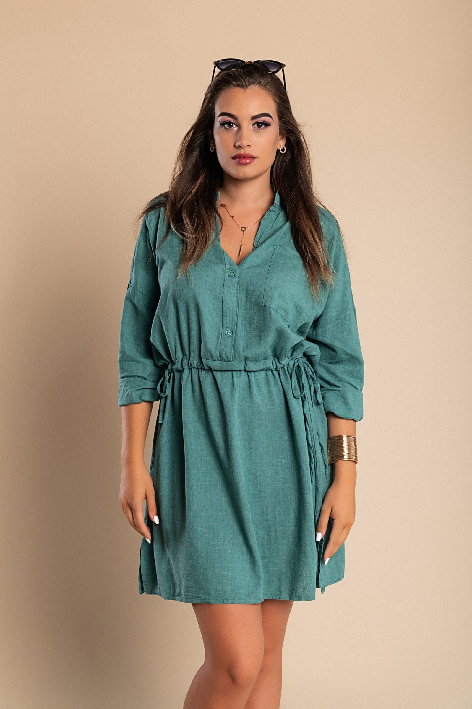 A stylish petroleum-colored mini dress featuring a classic collar, long sleeves, front button closure, and a decorative pocket, perfect for various occasions.