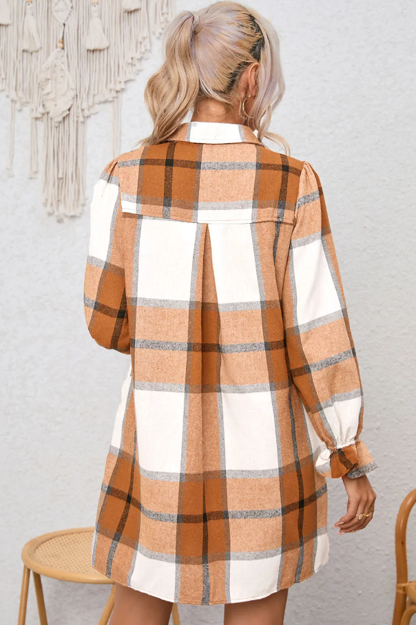 Mini srajčna obleka s karo potiskom v kaki barvi, ohlapnega kroja z dolgimi rokavi in gumbnim zapenjanjem.