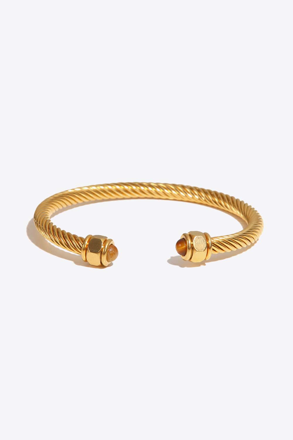 A flat lay image of a Stainless Steel Twisted C-Shaped Bracelet showcasing its modern minimalist design and twisted craftsmanship.