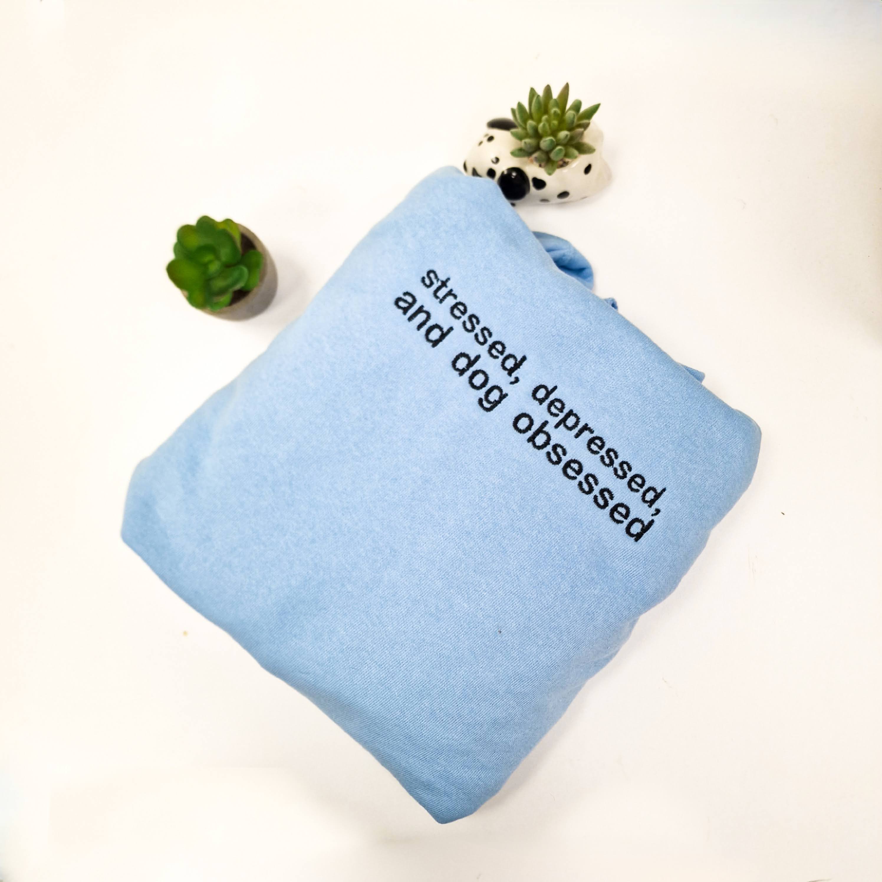 Cozy sweatshirt with 'Stressed, Depressed, and Dog Obsessed' embroidered design, perfect for dog lovers.