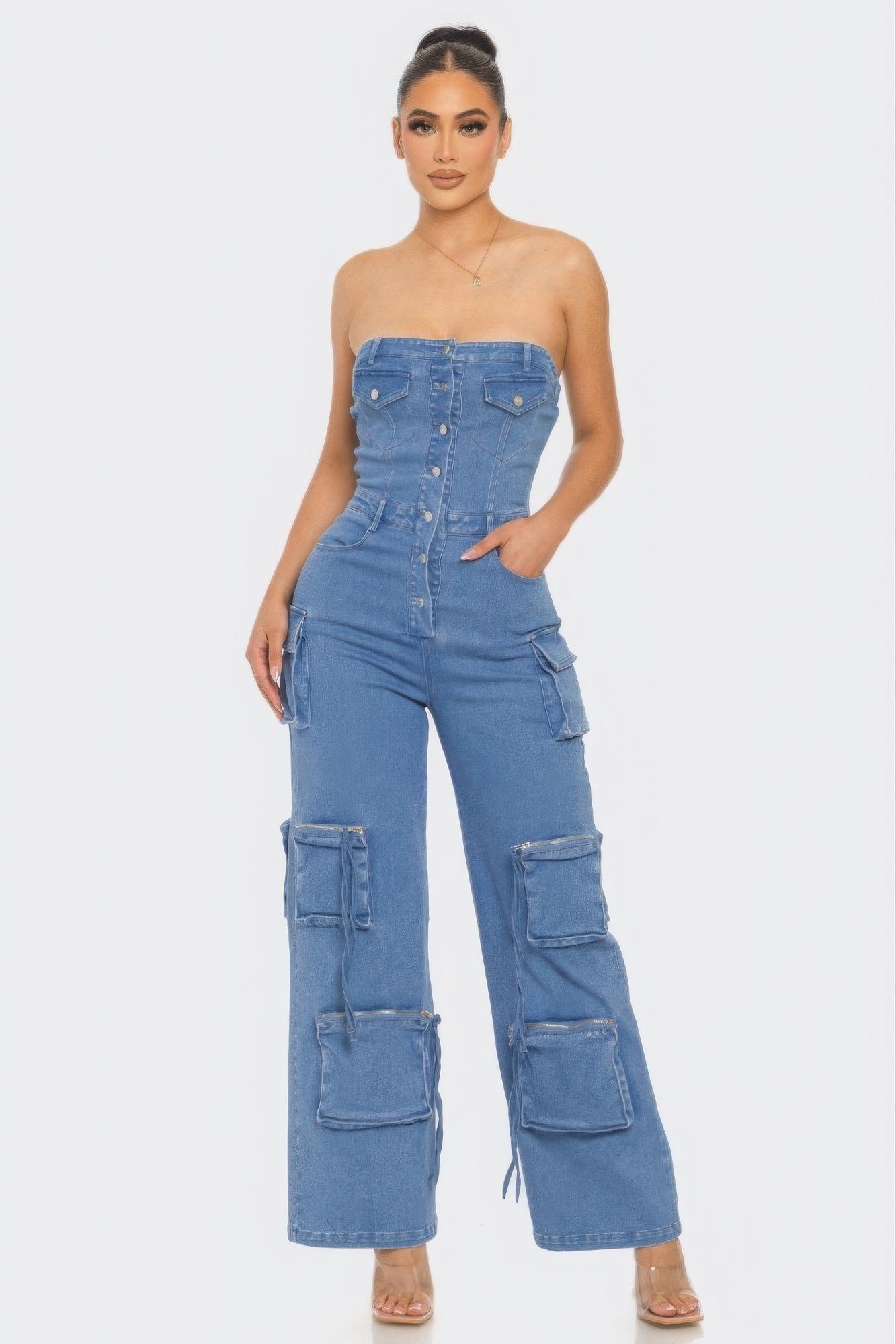 A stylish Stretch Denim Jumpsuit featuring a strapless neckline, metal button closure, and functional pockets in Medium Wash Denim.