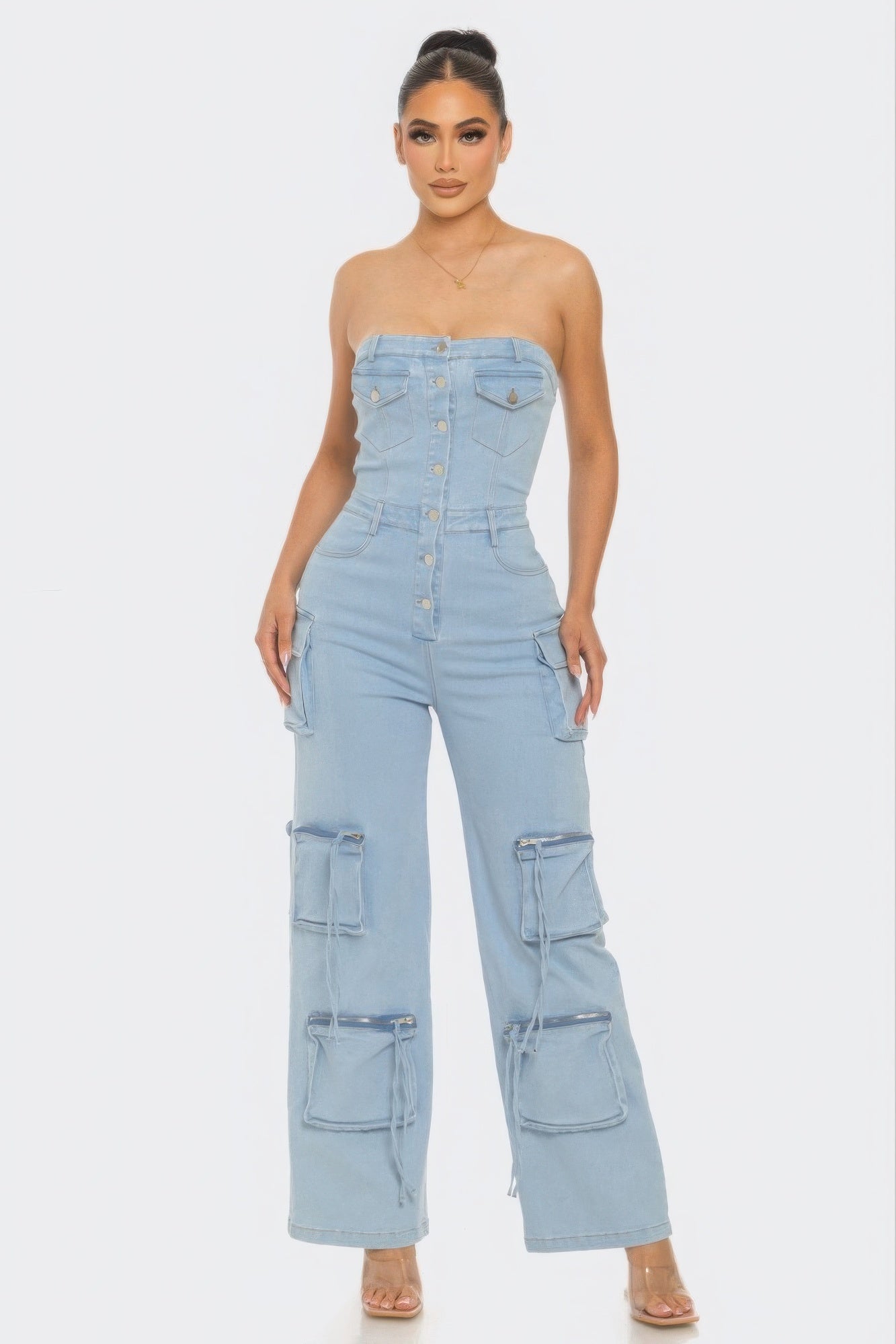 A stylish Stretch Denim Jumpsuit featuring a strapless neckline, metal button closure, and functional pockets in light denim color.