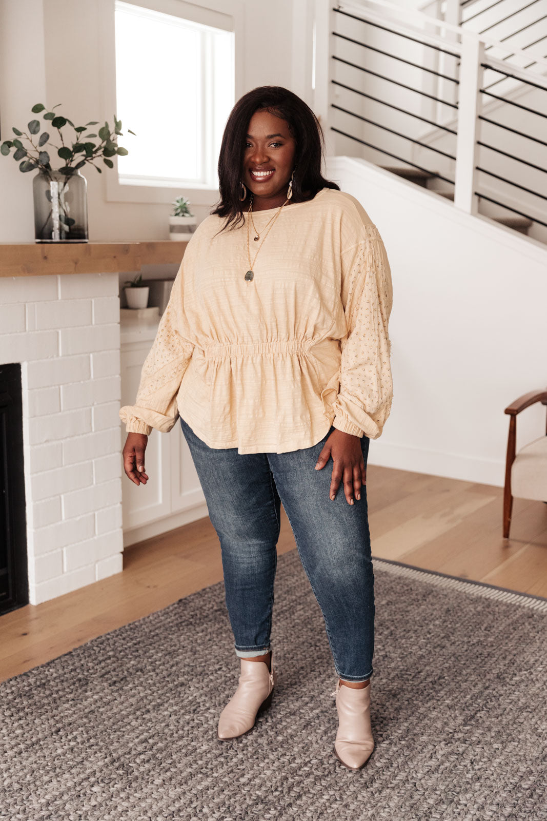 A stylish peach floral top featuring balloon dolman sleeves and an elastic waistband, perfect for a feminine look.