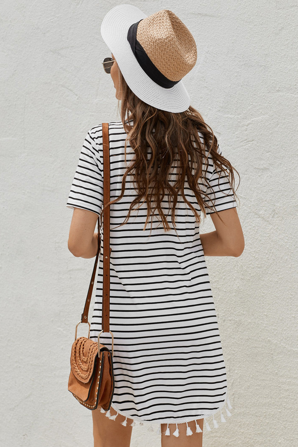 A stylish striped t-shirt dress featuring tassel details and a round neckline, perfect for casual outings.