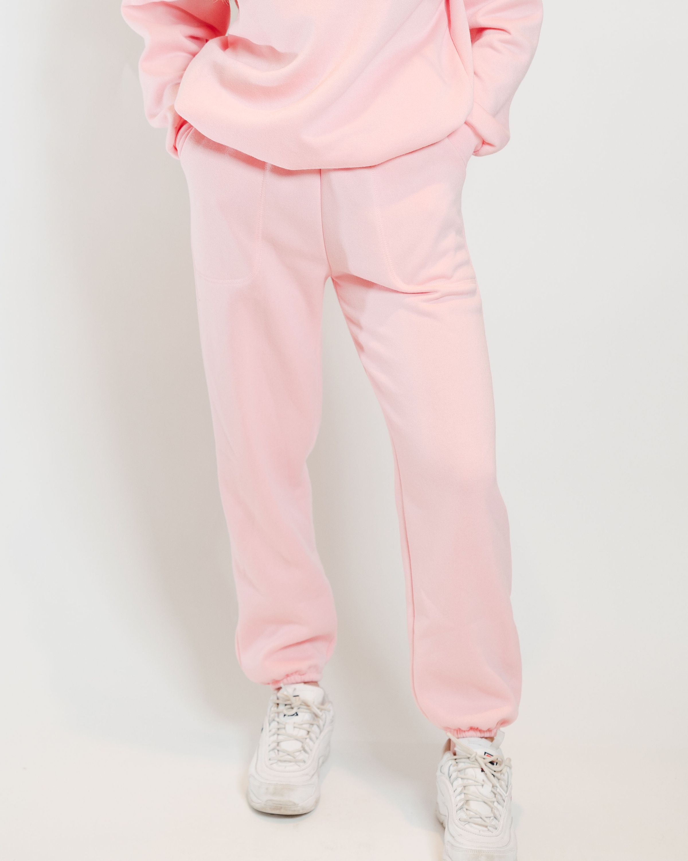 A pair of soft pink sweatpants designed for comfort and style, featuring an elastic waistband and a cozy interior.