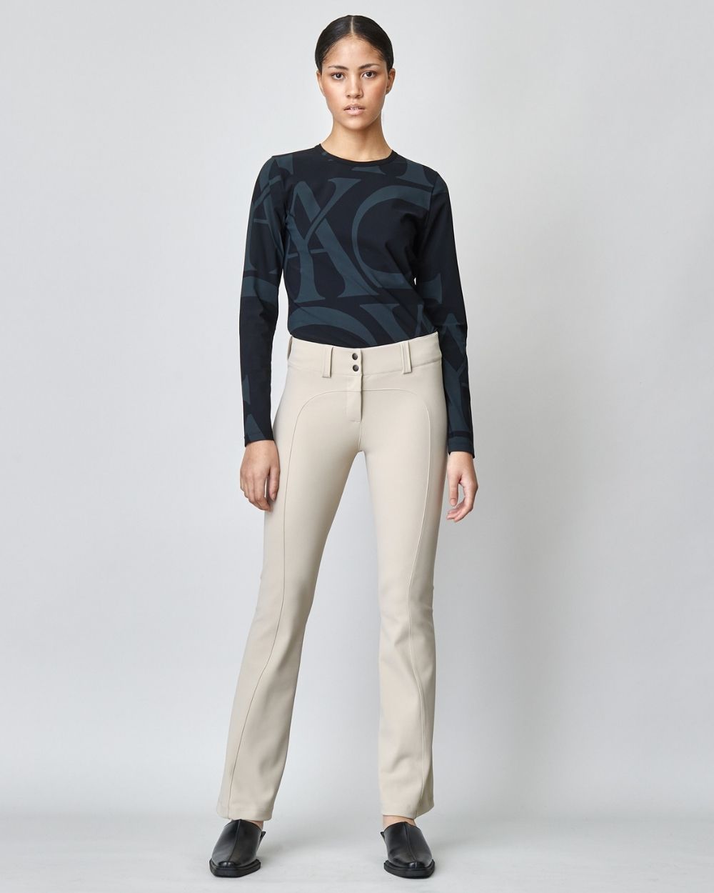 A pair of stylish Tailored Trousers in tan color, featuring a flared leg and high waist design, made from lightweight Italian jersey fabric.