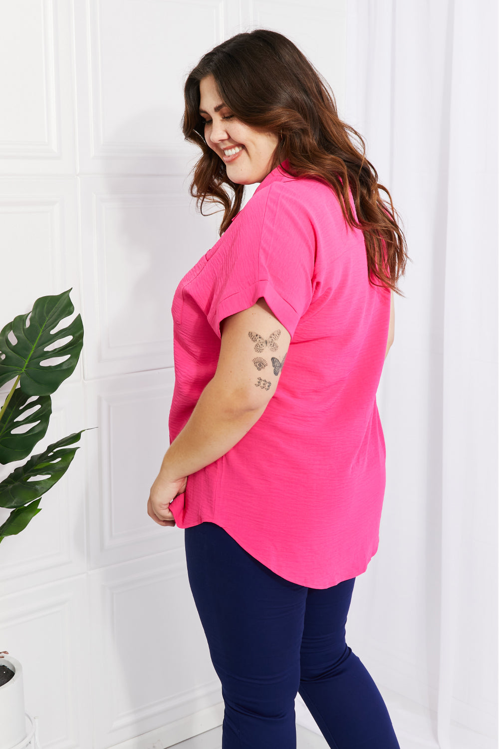 A stylish long-length button-up shirt with a curved hem, short cuffed sleeves, and breast pockets, perfect for warm weather.