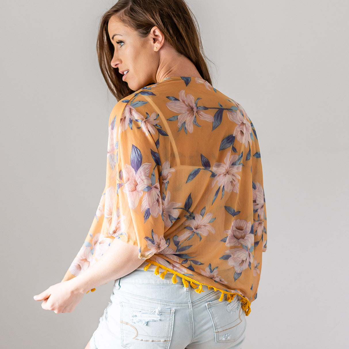 A stylish tassel trim kimono with a floral motif, perfect for spring and summer layering.