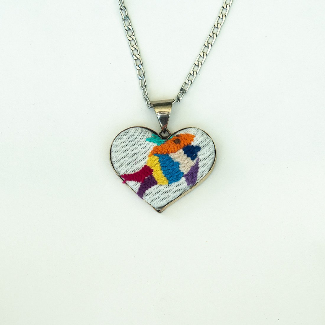 Colorful Tenango de Doria Embroidered Heart Necklace with unique Otomi embroidery on aluminum pendant.