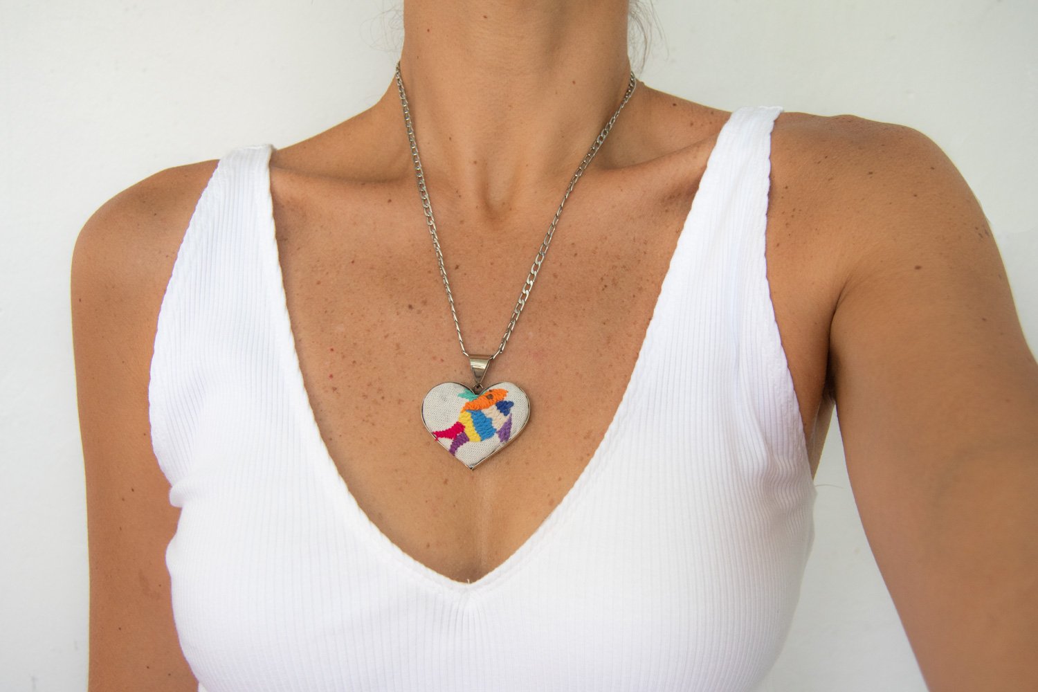 Colorful Tenango de Doria Embroidered Heart Necklace with unique Otomi embroidery on aluminum pendant.