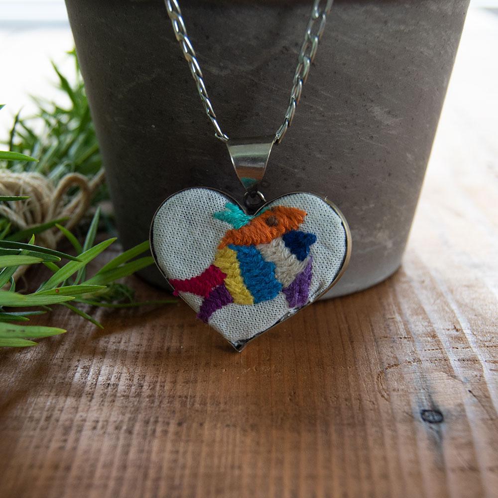 Colorful Tenango de Doria Embroidered Heart Necklace with unique Otomi embroidery on aluminum pendant.