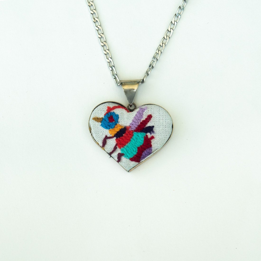 Colorful Tenango de Doria Embroidered Heart Necklace with unique Otomi embroidery on aluminum pendant.