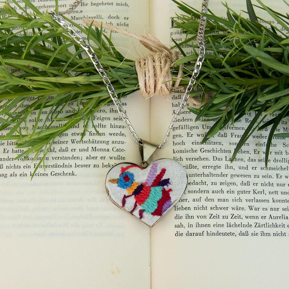 Colorful Tenango de Doria Embroidered Heart Necklace with unique Otomi embroidery on aluminum pendant.