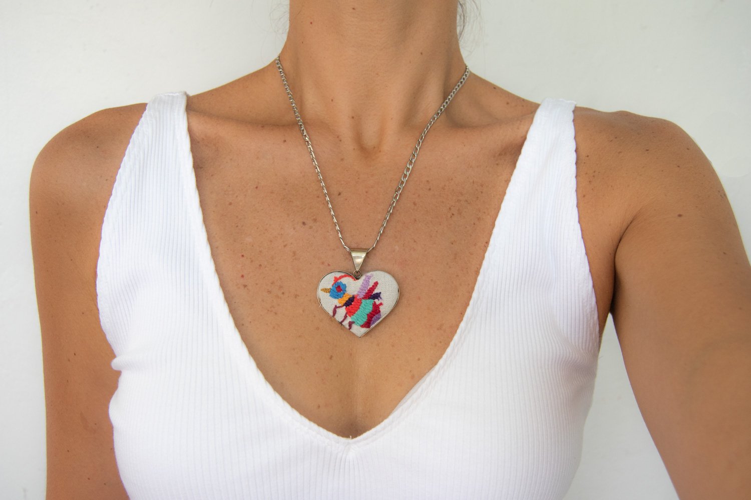 Colorful Tenango de Doria Embroidered Heart Necklace with unique Otomi embroidery on aluminum pendant.