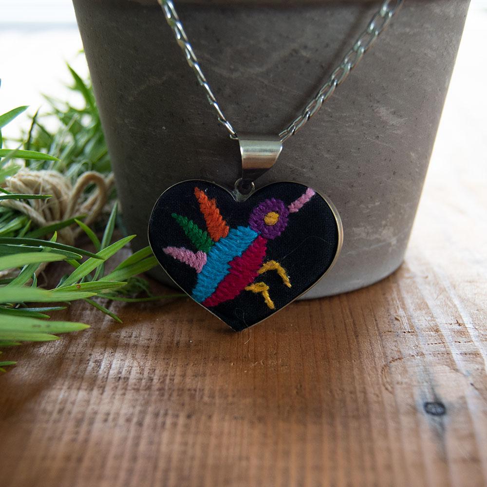 Colorful Tenango de Doria Embroidered Heart Necklace with unique Otomi embroidery on aluminum pendant.