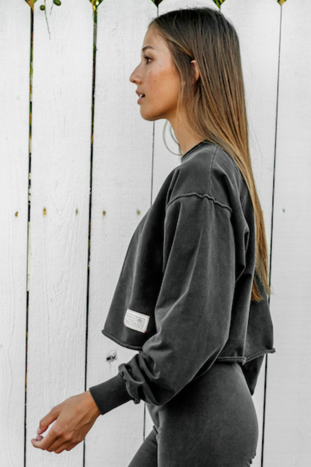 The Happiness Sweatshirt in washed black, showcasing its soft fabric and flattering fit, perfect for casual outings.