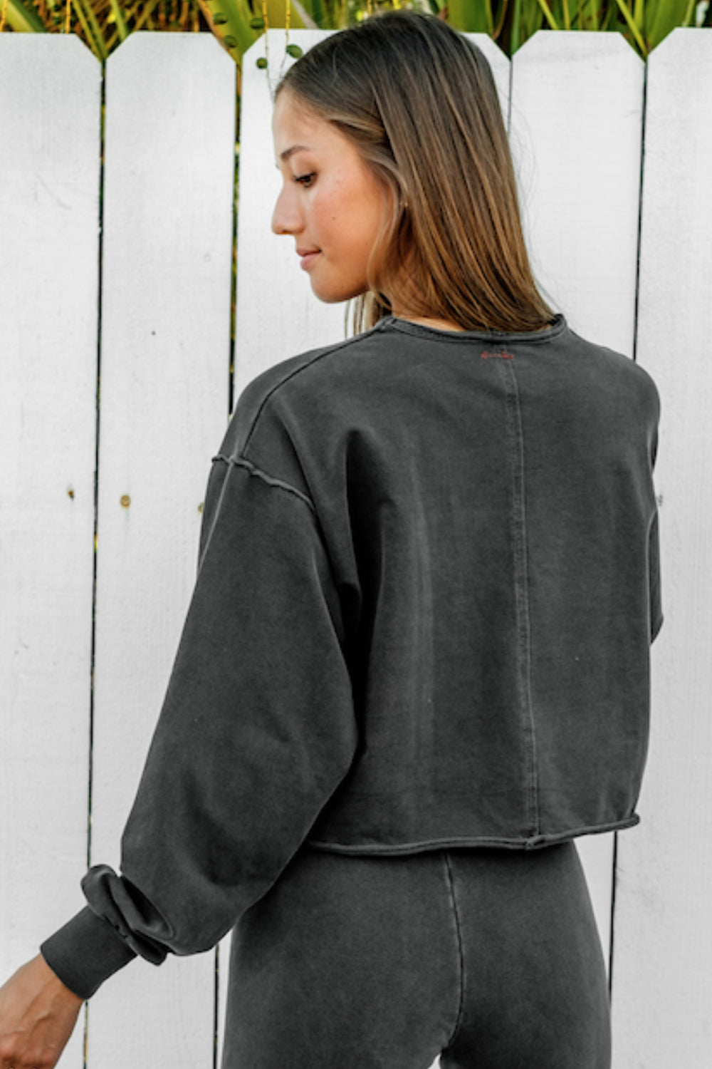 The Happiness Sweatshirt in washed black, showcasing its soft fabric and flattering fit, perfect for casual outings.