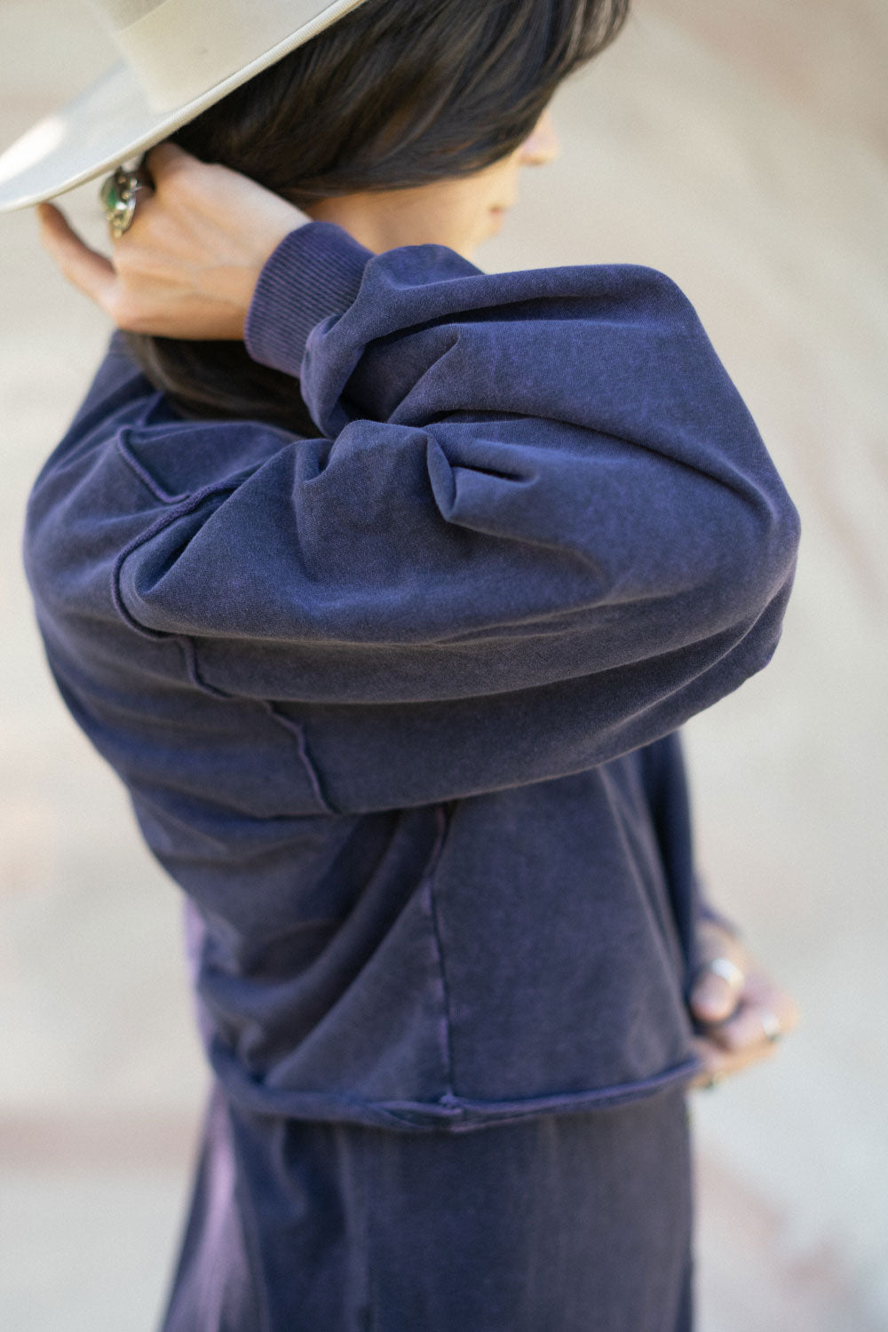 The Happiness Sweatshirt in washed black, showcasing its soft fabric and flattering fit, perfect for casual outings.