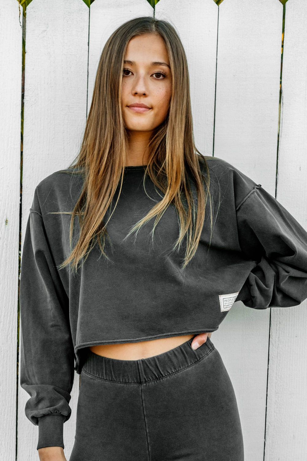 The Happiness Sweatshirt in washed black, showcasing its soft fabric and flattering fit, perfect for casual outings.