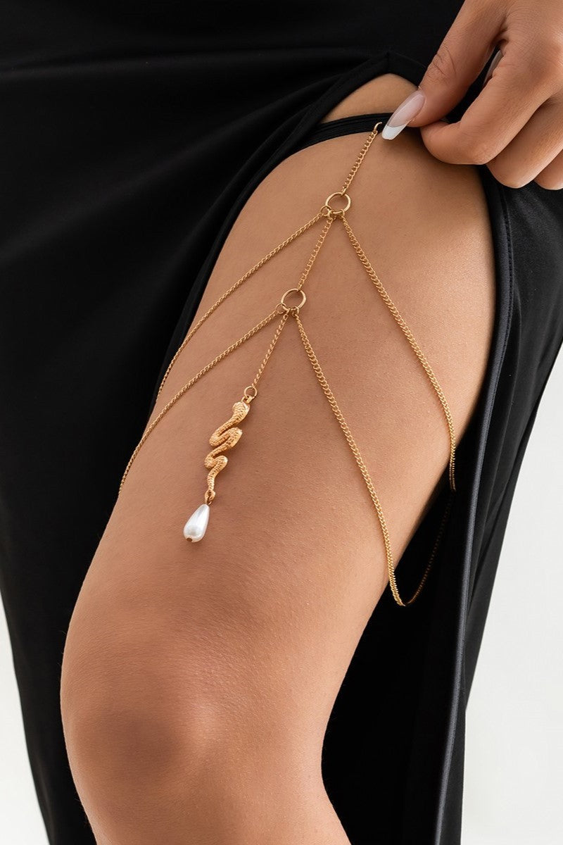 Gold thigh chain featuring a snake-shaped pendant, elegantly designed with fine chains and an elastic band.