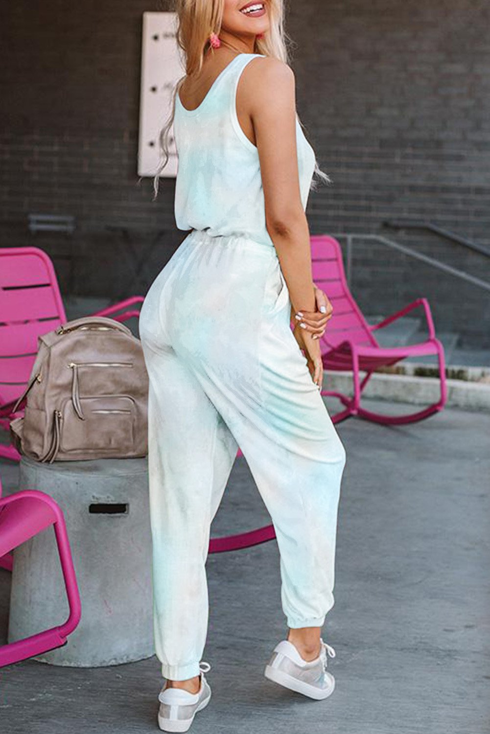 A stylish tie dye drawstring jogging jumpsuit featuring a scooped neckline, chest pocket, and relaxed jogger style with fitted ankle hems.