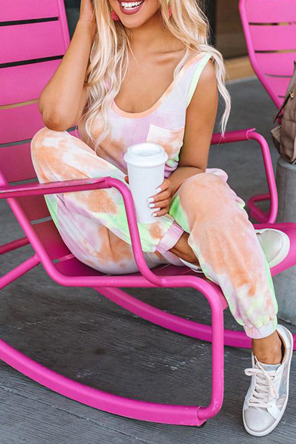 A stylish tie dye drawstring jogging jumpsuit featuring a scooped neckline, chest pocket, and relaxed jogger style with fitted ankle hems.
