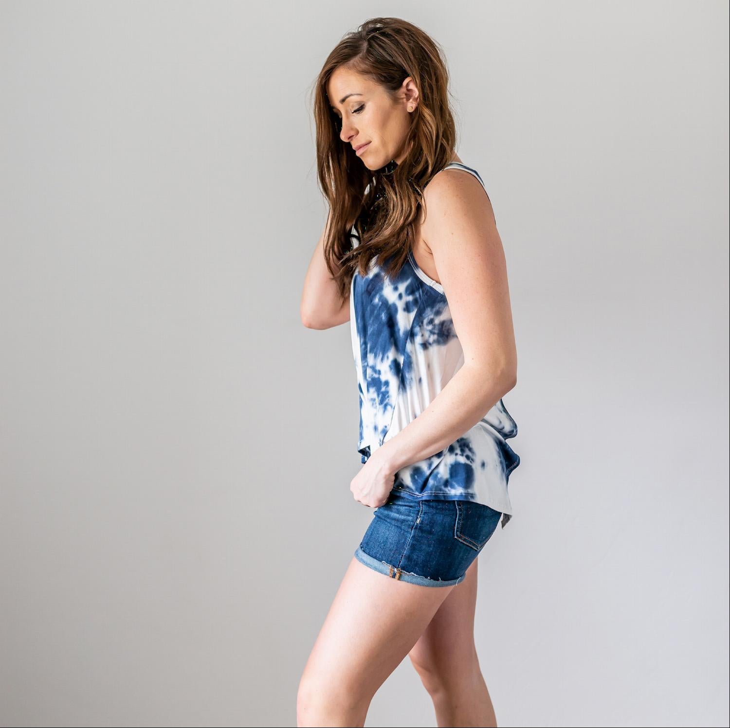 A vibrant tie dye tank top with a split tail and adjustable tie back, perfect for summer wear.