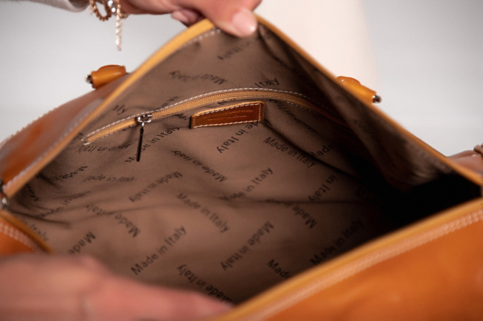 Elegantna svetlo rjava torba iz naravnega usnja Ava, ročno izdelana v Firencah, z več predali in kovinskimi zadrgami.