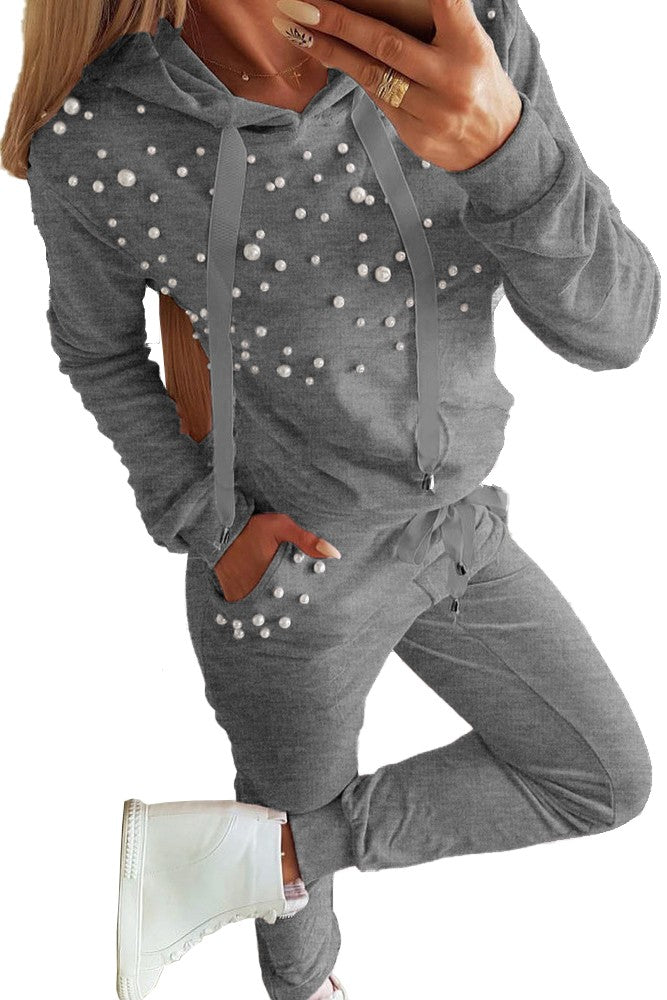 Siva trenirka komplet s kapuco in detajlom perlic, vključuje majico in dolge hlače, izdelana iz mehkega bombaža.