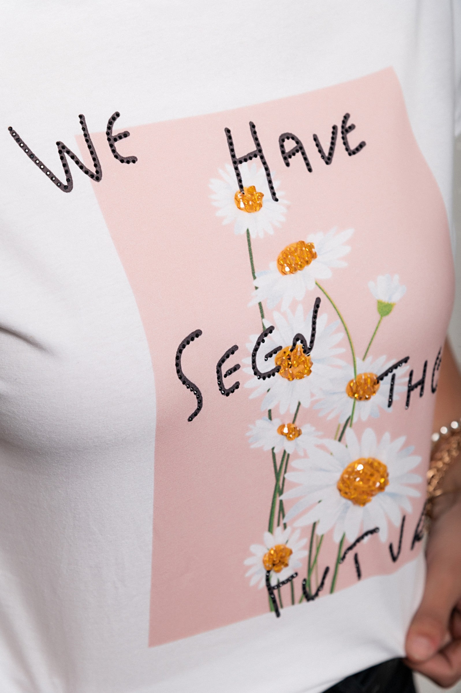 Light pink short-sleeved T-shirt with decorative details and round collar, featuring a dot print and ribbons on the back.