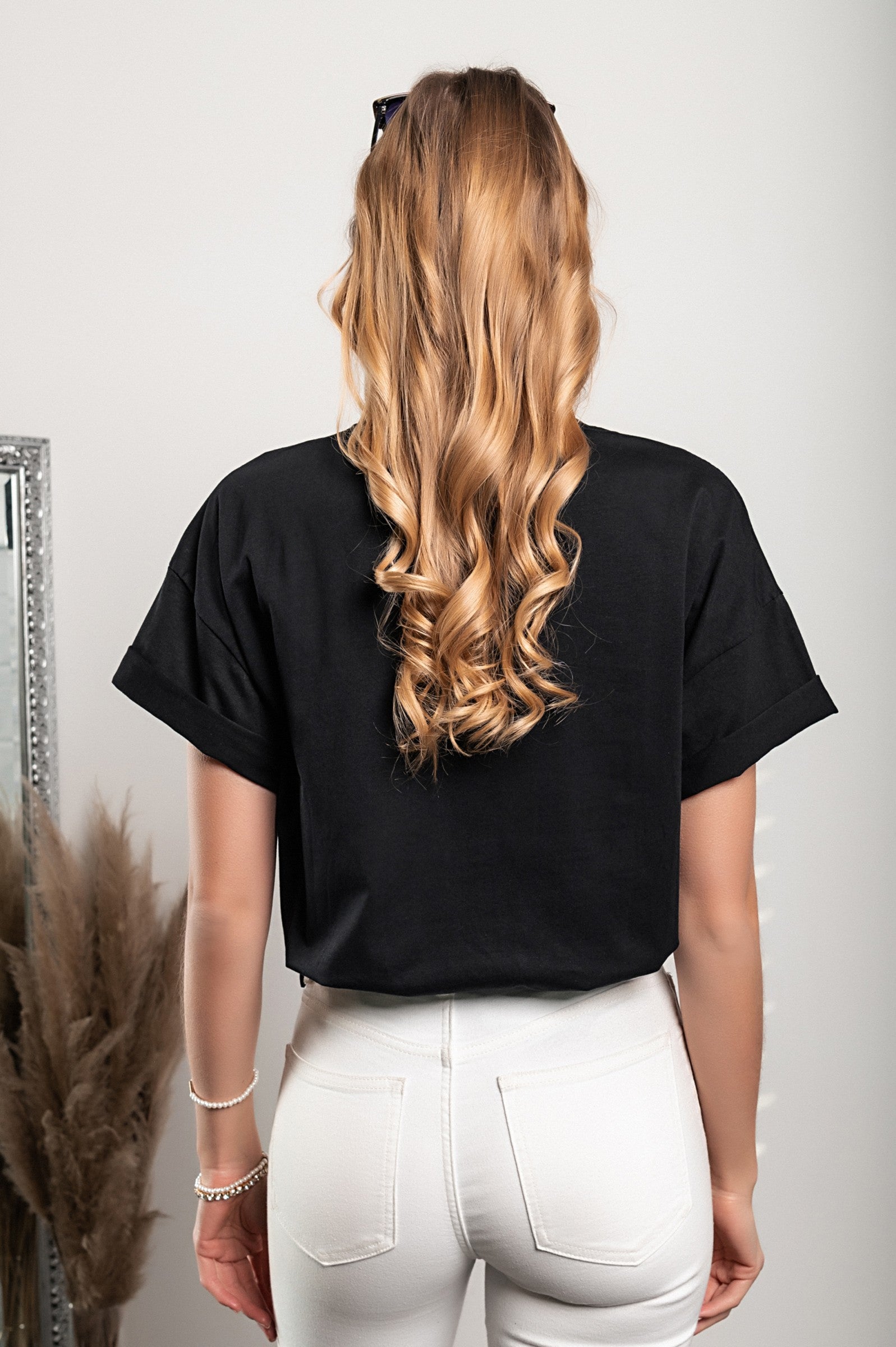 Black short-sleeve T-shirt with decorative details and round collar, showcasing a loose fit and high-quality fabric.