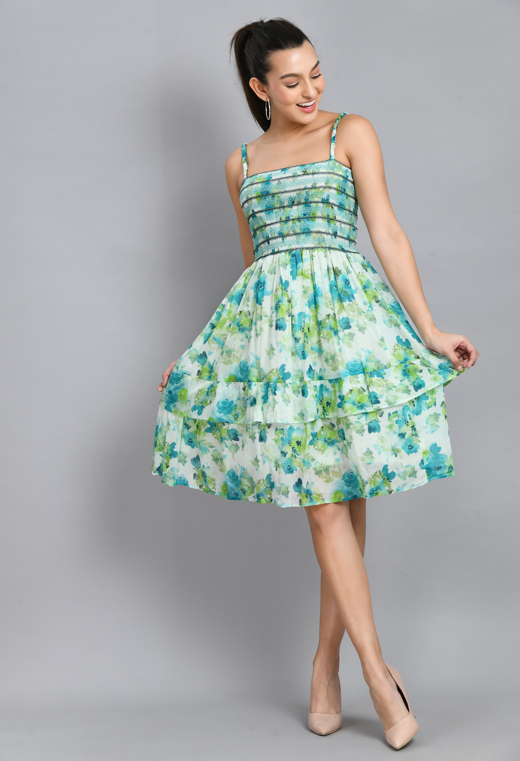 A stylish turquoise smoking short dress with floral pattern, sleeveless design, and asymmetrical hem, perfect for casual wear.