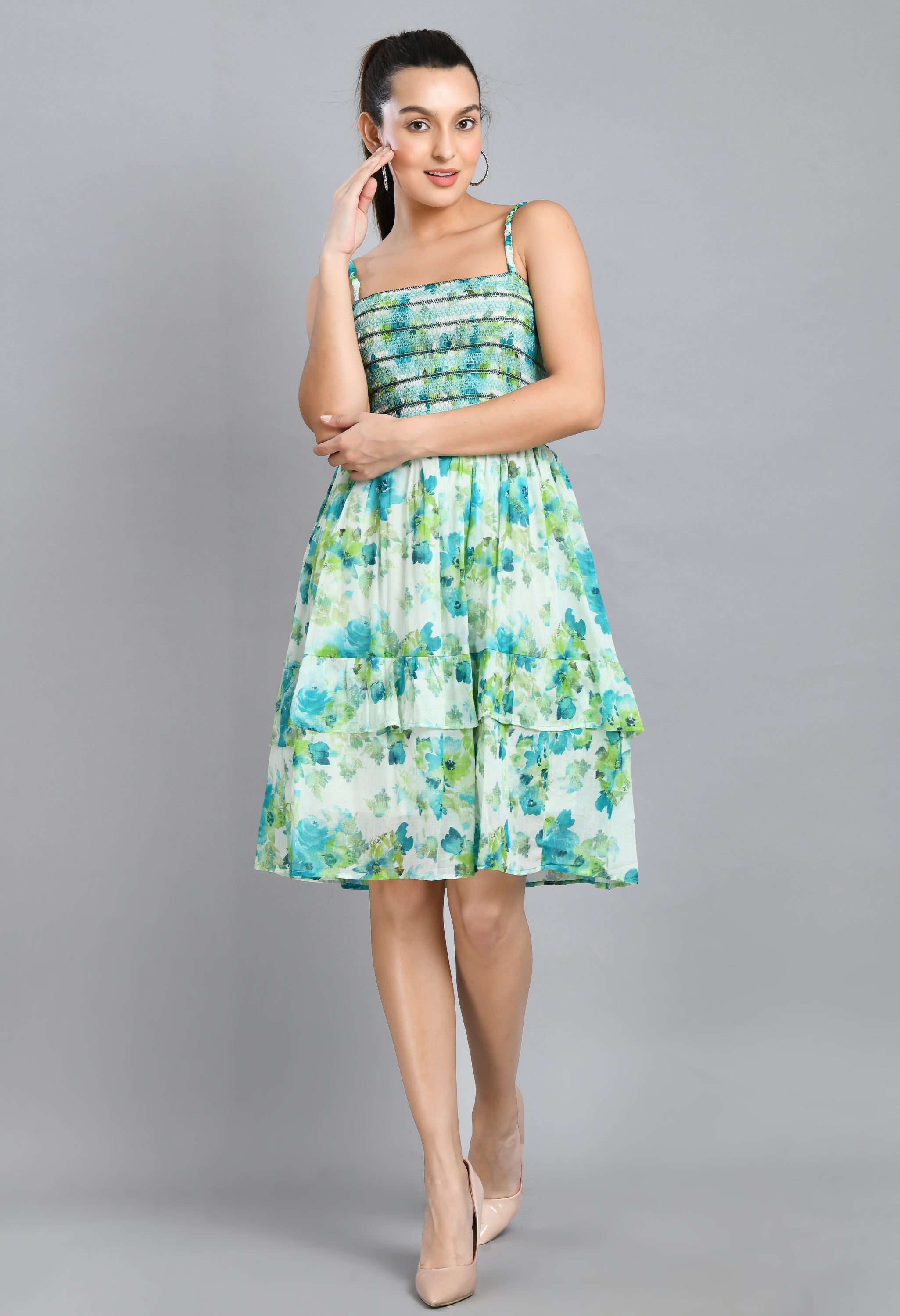 A stylish turquoise smoking short dress with floral pattern, sleeveless design, and asymmetrical hem, perfect for casual wear.