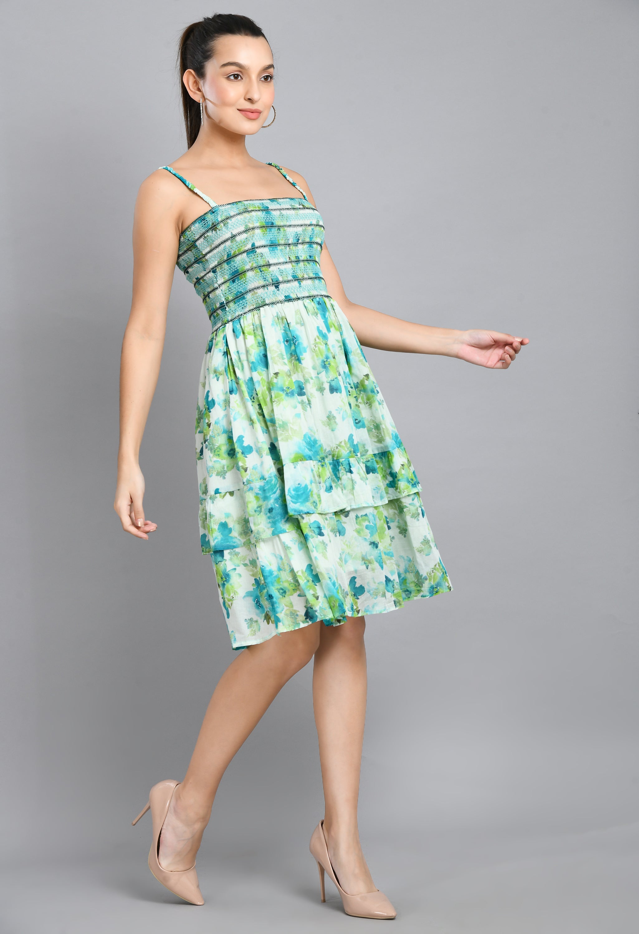 A stylish turquoise smoking short dress with floral pattern, sleeveless design, and asymmetrical hem, perfect for casual wear.