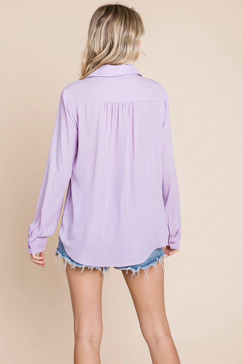 A stylish V neck collared blouse with two front pockets, featuring long sleeves and a button front, displayed on a mannequin.