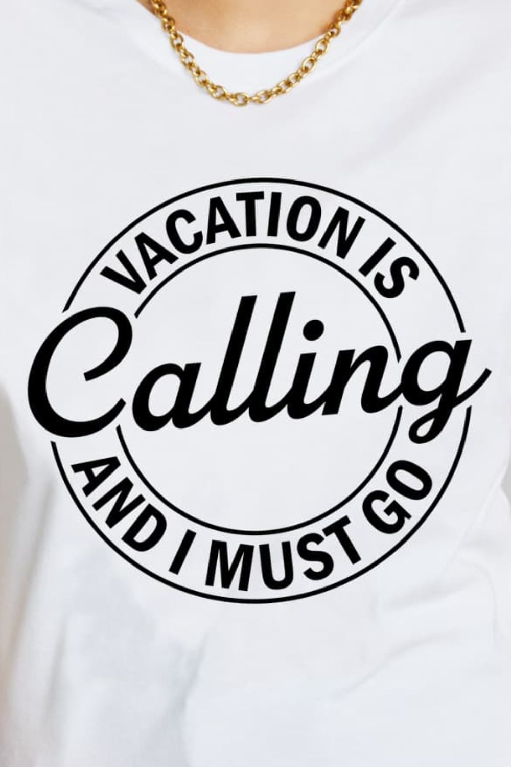 A casual graphic cotton t-shirt featuring the phrase 'VACATION IS CALLING AND I MUST GO' in vibrant colors, perfect for travel enthusiasts.