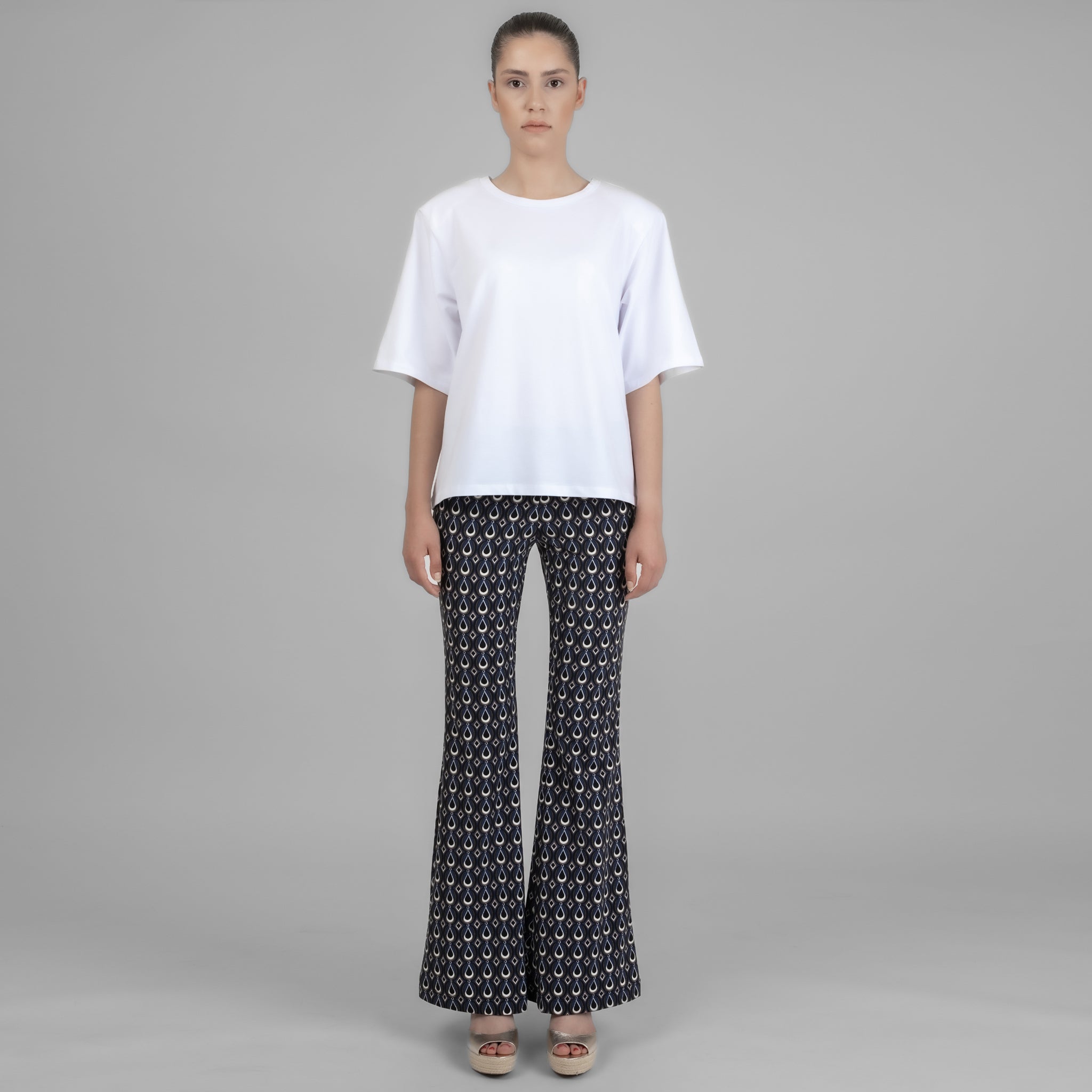 A stylish white shoulder pad tee, Vatkalı Kısa Kollu Beyaz Lucy Basic, displayed on a model, showcasing its elegant design and soft fabric.