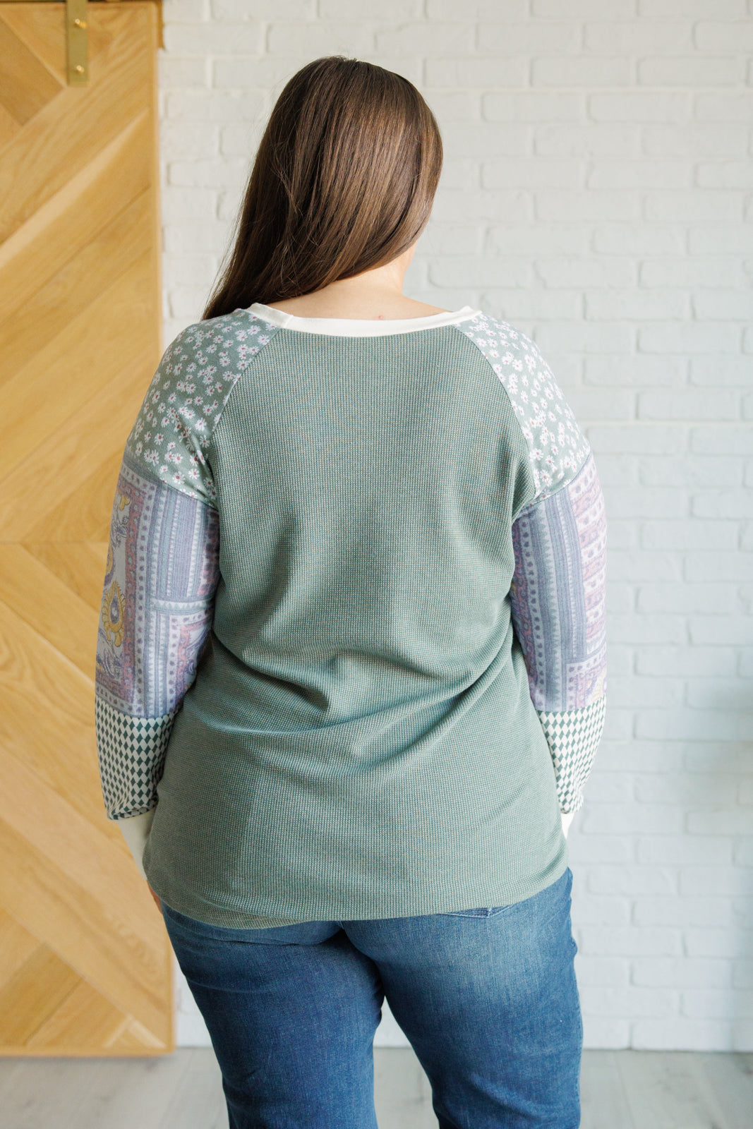 A stylish Very Curious Mixed Print Top featuring a waffle knit bodice and floral raglan sleeves, perfect for casual wear.